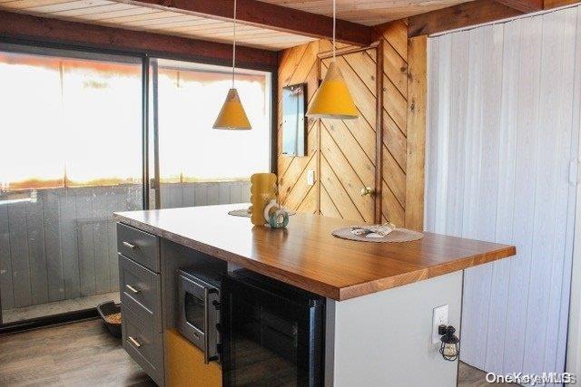 interior space featuring decorative light fixtures, wood walls, dark hardwood / wood-style flooring, and wooden ceiling