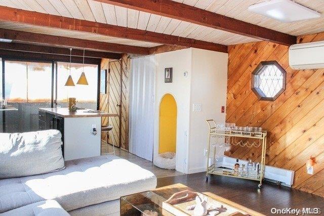 living room with dark hardwood / wood-style flooring, an AC wall unit, wooden ceiling, beamed ceiling, and wood walls