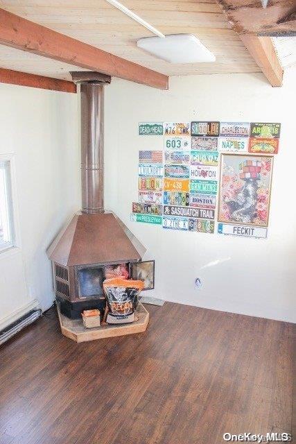 interior details with a wood stove, hardwood / wood-style floors, and beamed ceiling