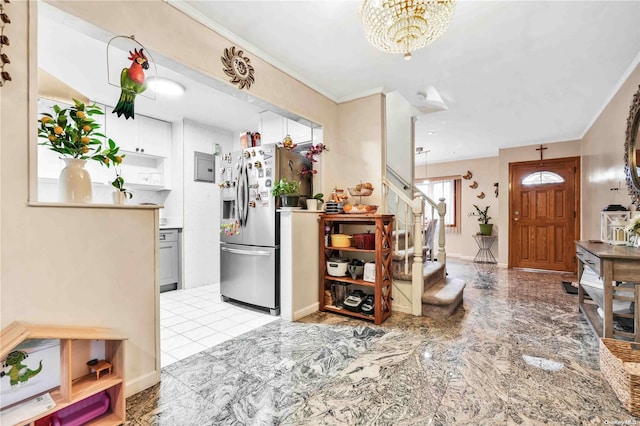 foyer entrance featuring crown molding and a notable chandelier