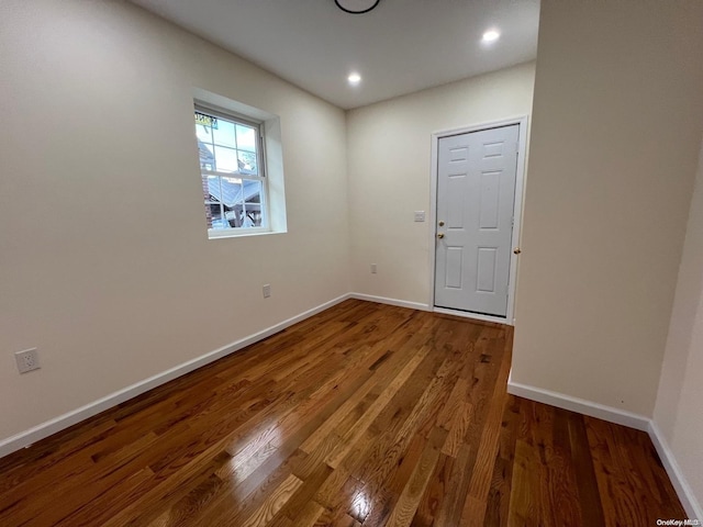 unfurnished room with dark hardwood / wood-style flooring