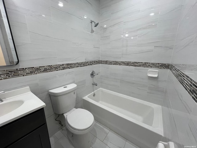 full bathroom with vanity, toilet, tile walls, and tiled shower / bath