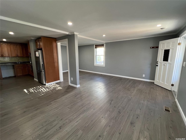 unfurnished living room with crown molding and dark wood-type flooring