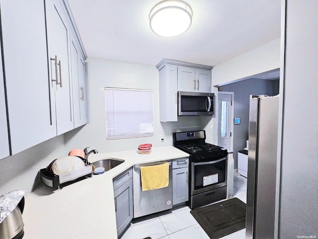 kitchen with gray cabinetry, sink, and appliances with stainless steel finishes