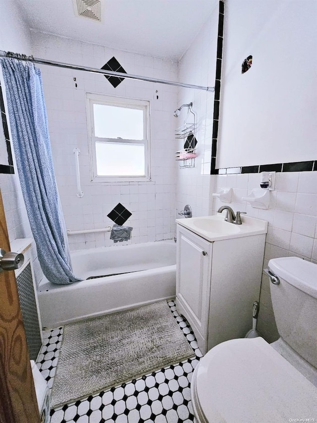 full bathroom featuring vanity, toilet, tile walls, and shower / tub combo with curtain