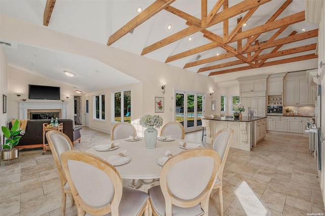 dining space featuring beamed ceiling, french doors, and high vaulted ceiling