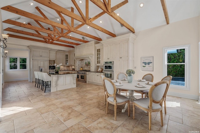 dining space with beam ceiling and high vaulted ceiling