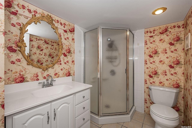 bathroom featuring tile patterned flooring, vanity, toilet, and walk in shower