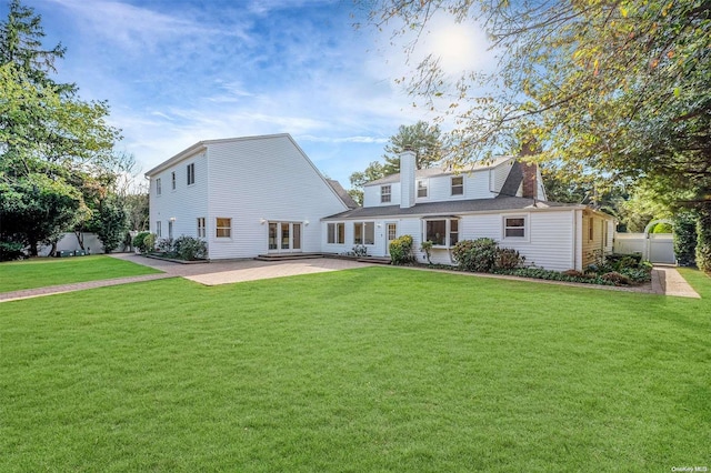 rear view of house with a yard and a patio