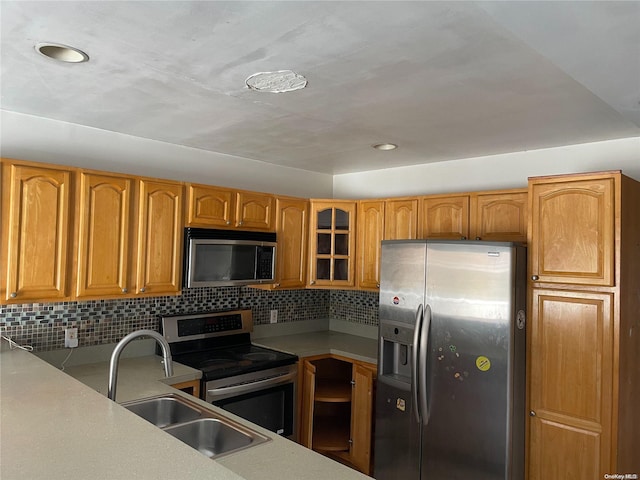 kitchen with decorative backsplash, stainless steel appliances, and sink