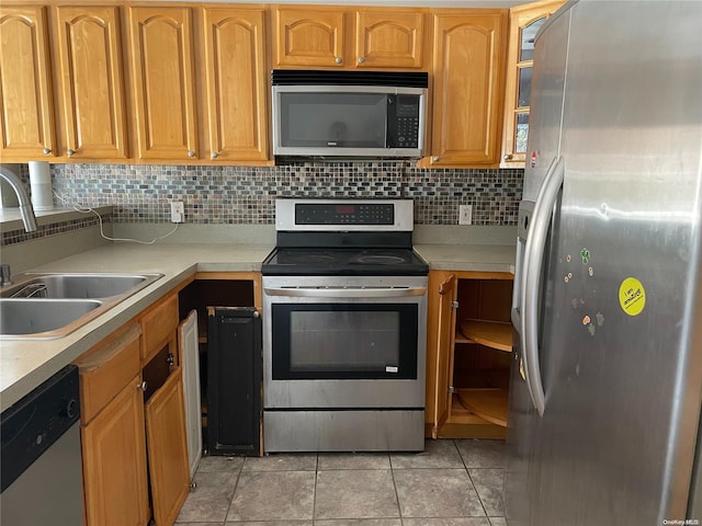 kitchen featuring light tile patterned flooring, backsplash, stainless steel appliances, and sink