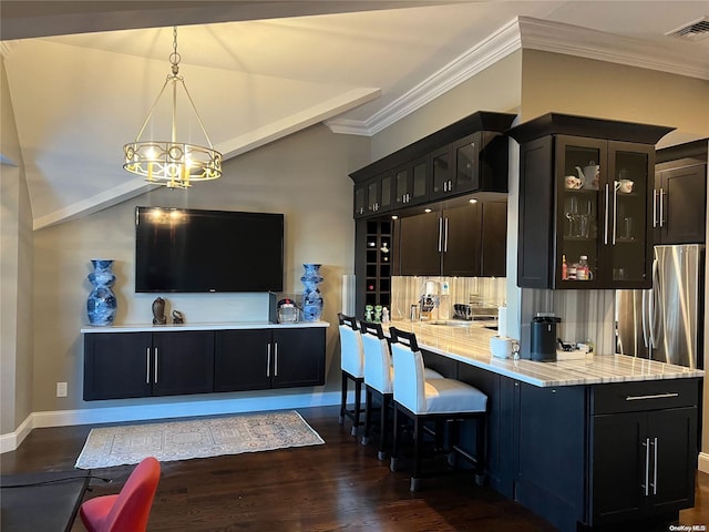 kitchen featuring light stone countertops, ornamental molding, dark wood-type flooring, pendant lighting, and a chandelier