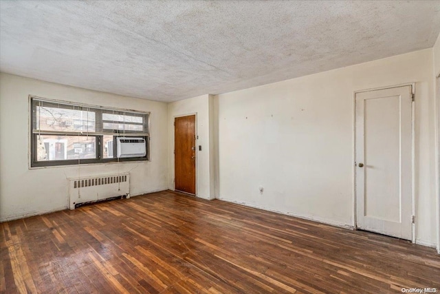 unfurnished room featuring radiator heating unit, a textured ceiling, cooling unit, and dark wood-type flooring