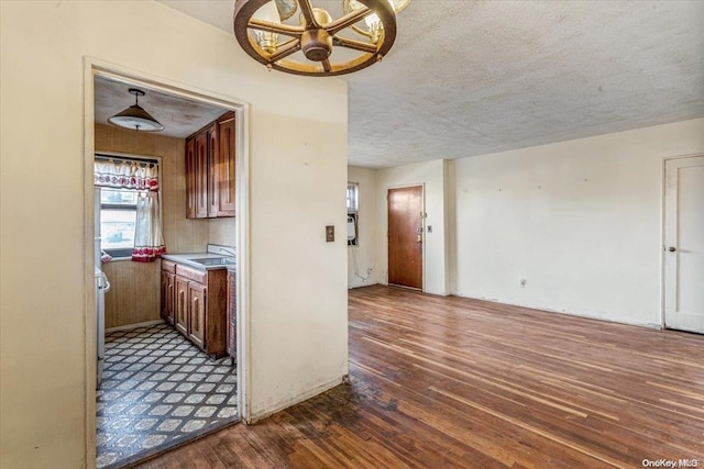 kitchen featuring a textured ceiling, ceiling fan, dark wood-type flooring, sink, and decorative light fixtures