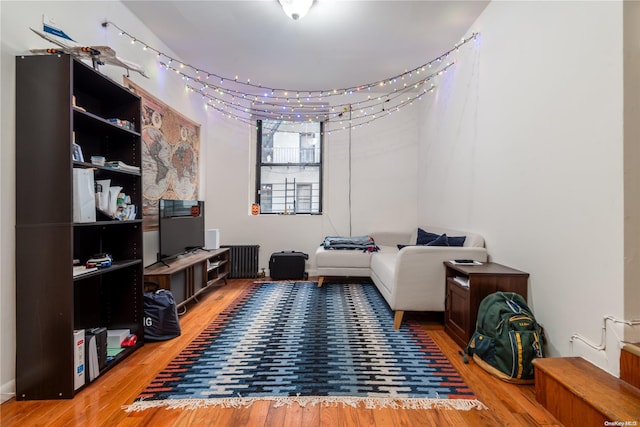 sitting room with hardwood / wood-style floors and radiator heating unit