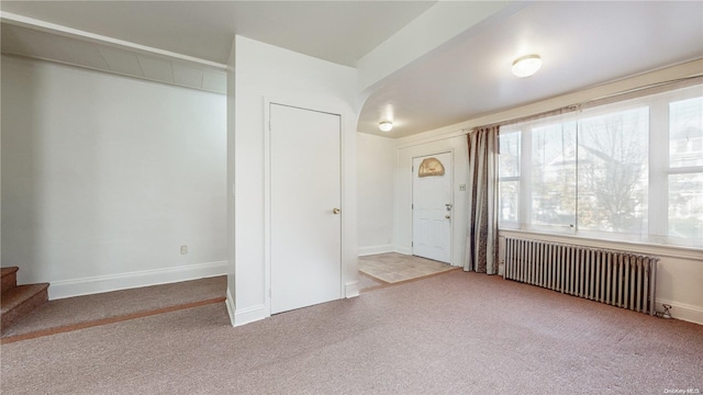 carpeted foyer entrance with radiator