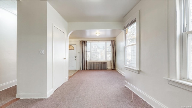 hallway featuring carpet flooring and radiator