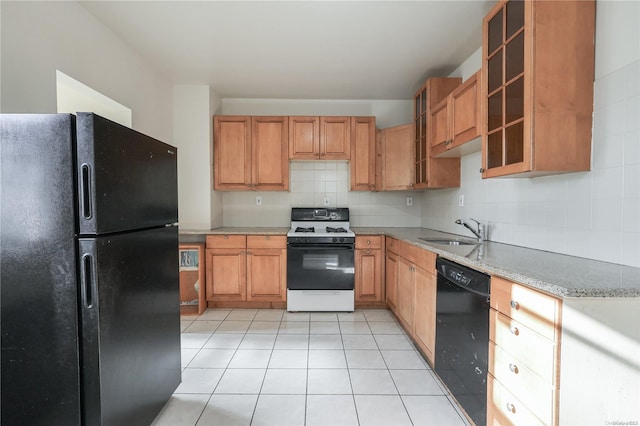 kitchen with light tile patterned floors, sink, backsplash, and black appliances