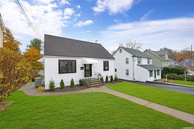 view of front of property with central AC and a front yard