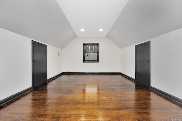 additional living space featuring dark hardwood / wood-style floors and lofted ceiling