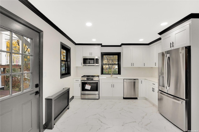 kitchen with plenty of natural light, white cabinets, and appliances with stainless steel finishes