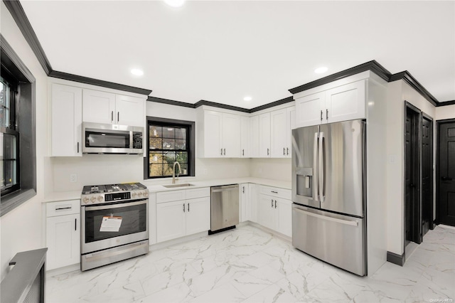 kitchen featuring white cabinets, appliances with stainless steel finishes, crown molding, and sink