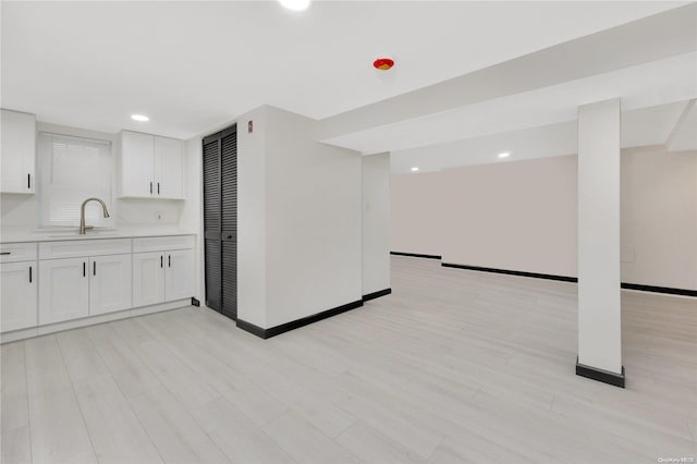 kitchen featuring white cabinets, light hardwood / wood-style floors, and sink