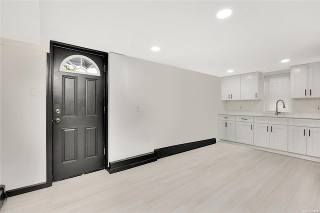 foyer entrance with sink and light hardwood / wood-style flooring