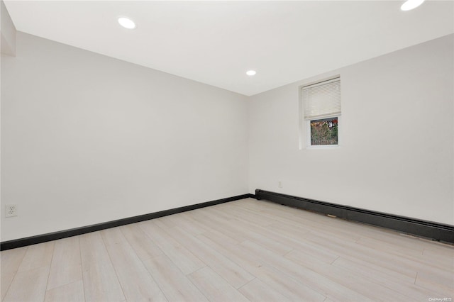 spare room with light wood-type flooring and a baseboard radiator