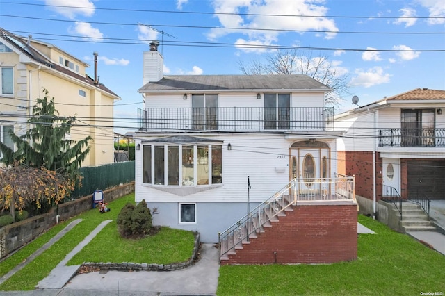 view of front facade featuring a balcony and a front yard