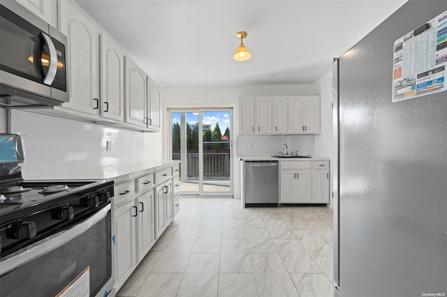 kitchen with decorative backsplash, white cabinetry, sink, and stainless steel appliances