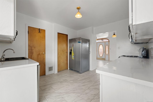 kitchen featuring sink, white cabinets, and stainless steel refrigerator with ice dispenser