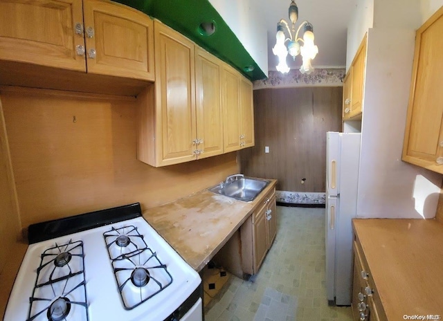 kitchen featuring white appliances, an inviting chandelier, sink, hanging light fixtures, and light brown cabinetry