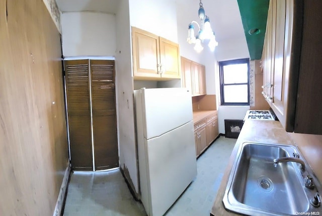 kitchen featuring sink, light brown cabinets, a chandelier, decorative light fixtures, and white appliances