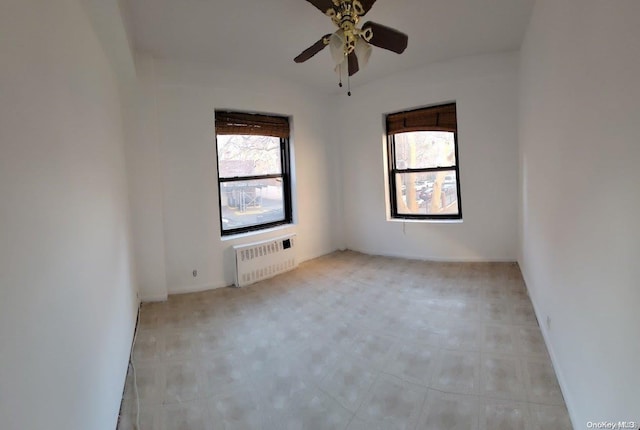 spare room with ceiling fan and radiator heating unit