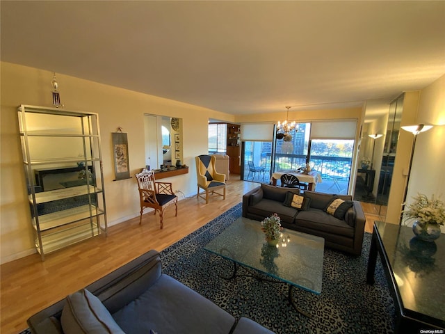 living room with hardwood / wood-style flooring, an inviting chandelier, and a wealth of natural light