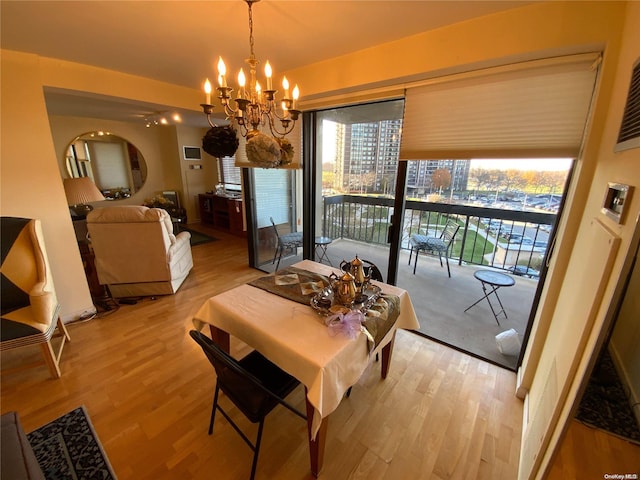 dining area featuring light hardwood / wood-style flooring and a notable chandelier