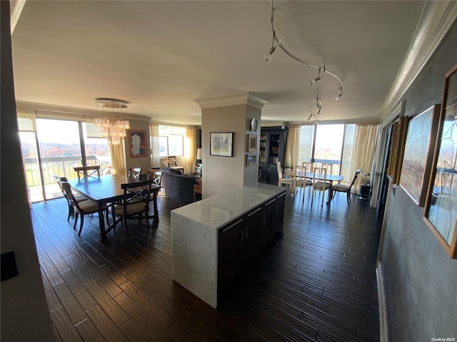 kitchen with a notable chandelier, a kitchen island, dark hardwood / wood-style flooring, and light stone counters