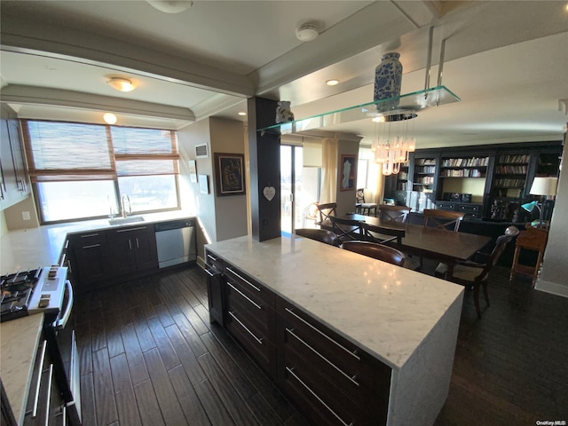 kitchen with a center island, sink, dark hardwood / wood-style floors, appliances with stainless steel finishes, and light stone counters