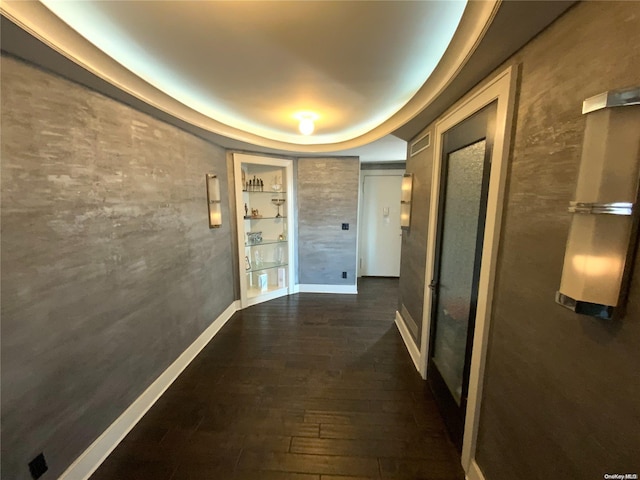 hallway featuring built in shelves and dark wood-type flooring