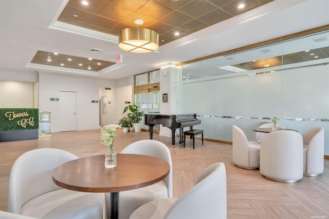 dining space with a tray ceiling and light parquet floors