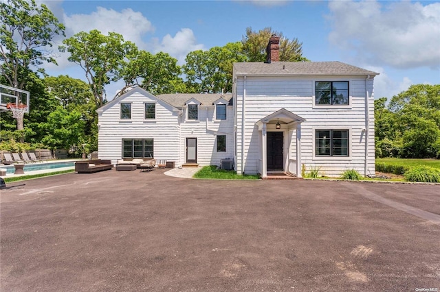 view of front of house featuring a patio, cooling unit, and a swimming pool