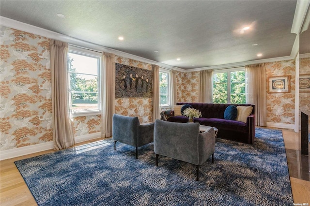 living room with hardwood / wood-style floors, a textured ceiling, ornamental molding, and a healthy amount of sunlight