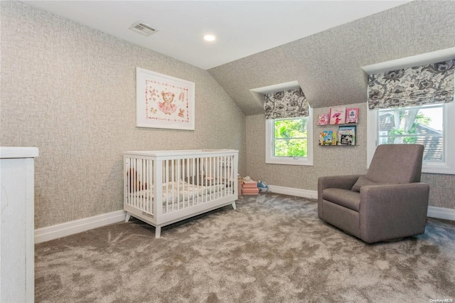 bedroom featuring multiple windows, carpet floors, vaulted ceiling, and a nursery area