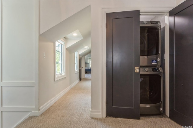 washroom with light colored carpet and stacked washer / dryer