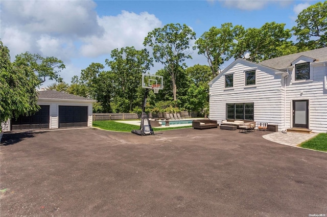 view of patio / terrace featuring a swimming pool and a garage