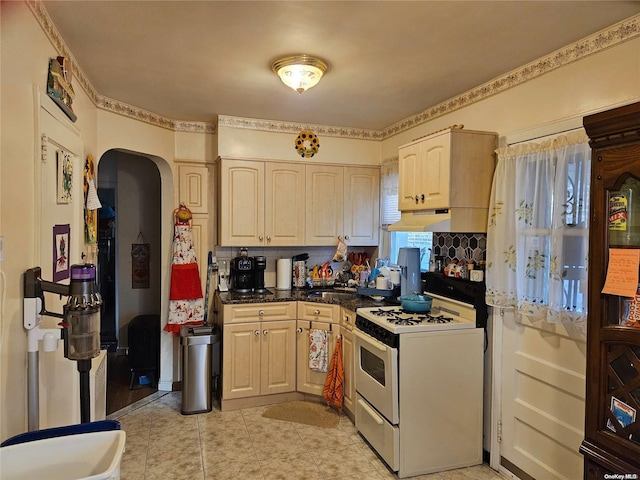 kitchen with white range with electric cooktop, sink, light tile patterned flooring, and light brown cabinetry