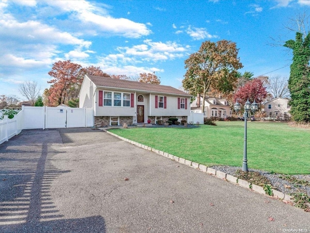 raised ranch featuring a front lawn