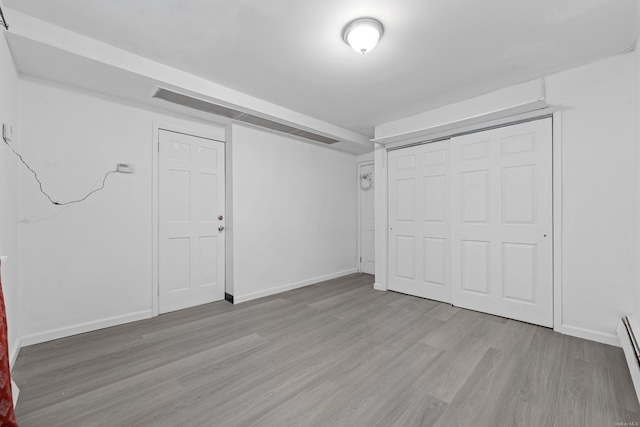 interior space featuring baseboard heating and light hardwood / wood-style floors