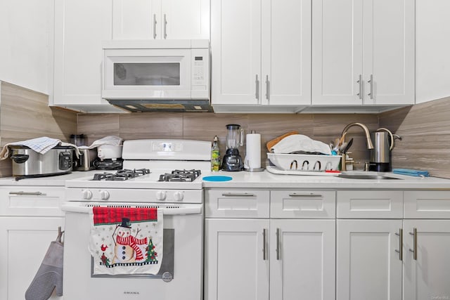 kitchen with white cabinetry and white appliances